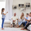 girl acting out charades with family