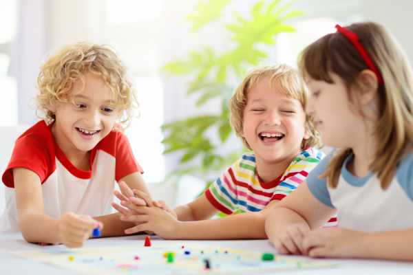 3 children happily playing a board game