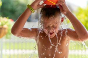 Boy accidentally spilling bowl of water over his head