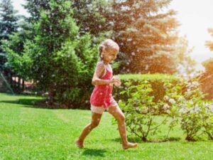 Girl running across grass lawn