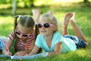 Girls sketching on paper in the park