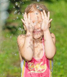 Delighted girl playing sponge tag water game