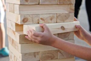 Teen building a giant Jenga block tower