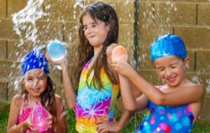 Three girls ready to shot put their water balloons