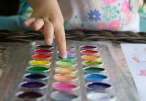 Toddler with tray of water colour paints