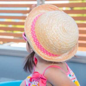 Young girl wearing straw hat and sunglasses for outdoor game